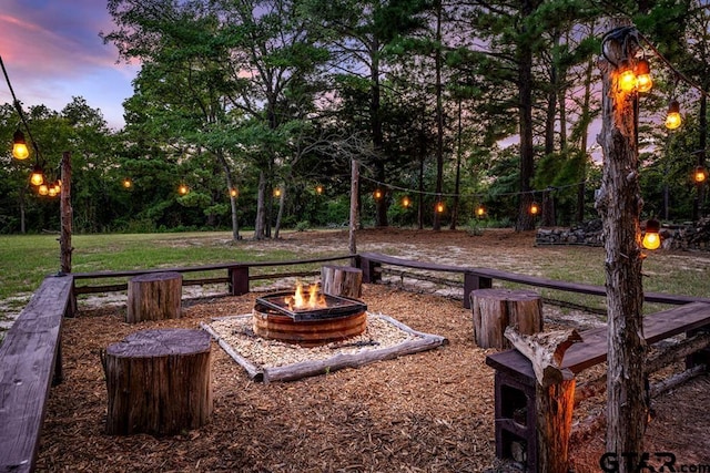 yard at dusk featuring an outdoor fire pit