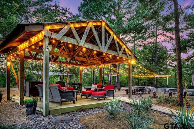 surrounding community featuring a wooden deck and an outdoor living space with a fire pit