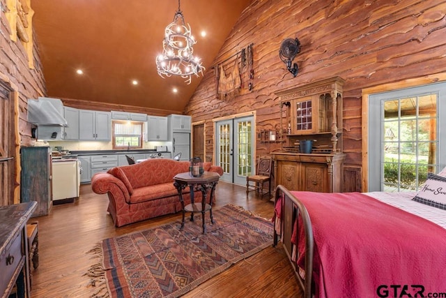 bedroom featuring access to exterior, dark hardwood / wood-style flooring, white refrigerator, and high vaulted ceiling