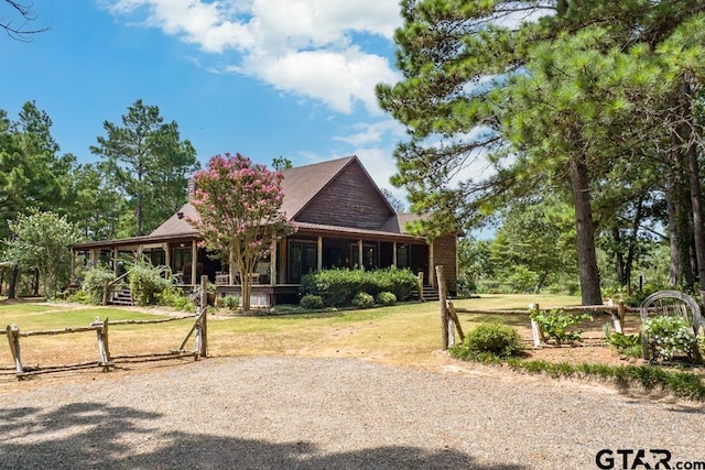 view of front of home with a sunroom and a front yard