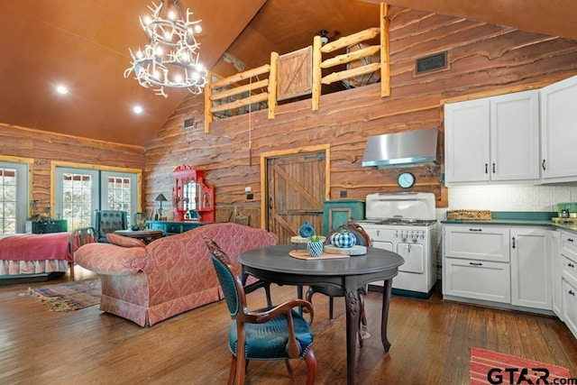 dining area with high vaulted ceiling, dark hardwood / wood-style floors, and an inviting chandelier