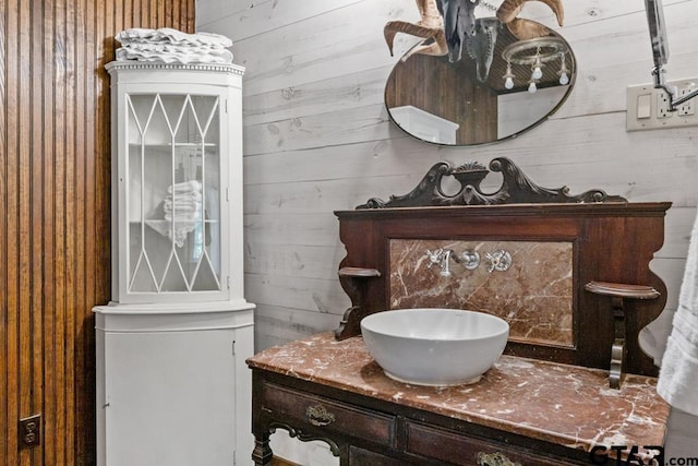 bathroom with vanity and wooden walls