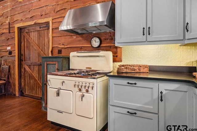 kitchen with backsplash, gas range gas stove, gray cabinetry, dark wood-type flooring, and range hood