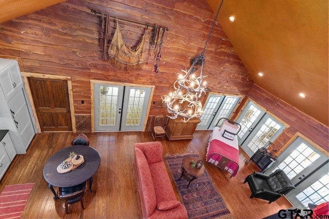 living room with french doors, high vaulted ceiling, a chandelier, and hardwood / wood-style flooring