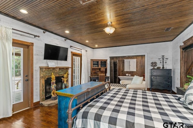 bedroom featuring dark hardwood / wood-style flooring, wood walls, a stone fireplace, and wooden ceiling