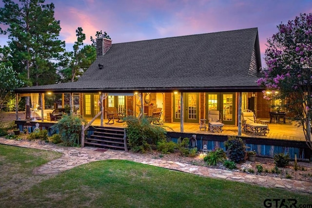 back house at dusk featuring a deck