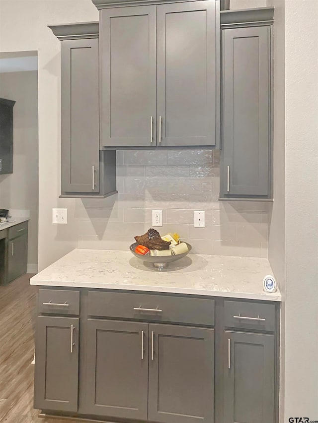 kitchen with tasteful backsplash and gray cabinetry