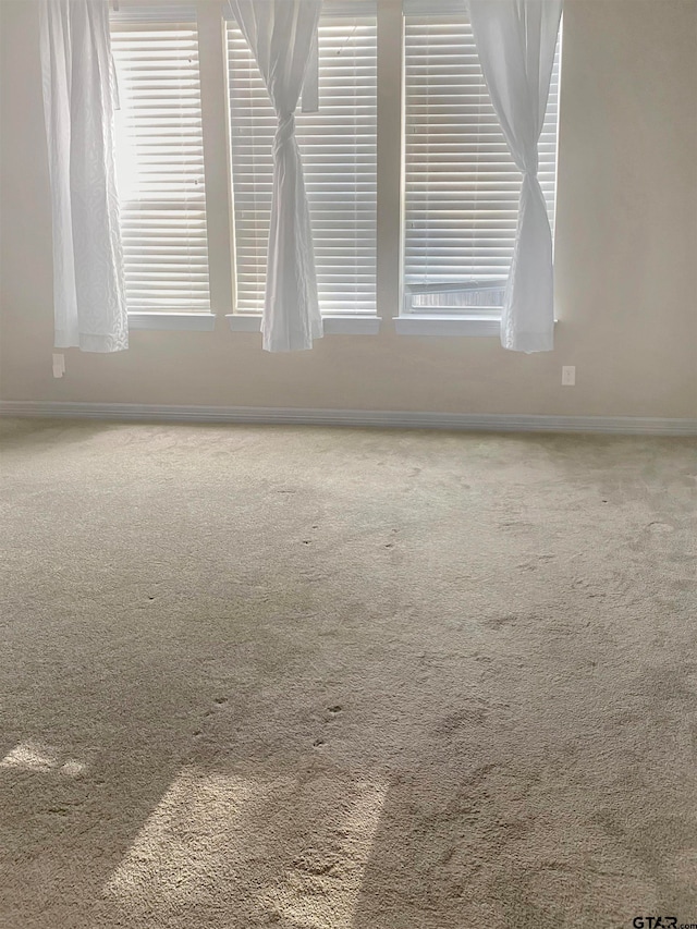 carpeted empty room featuring plenty of natural light