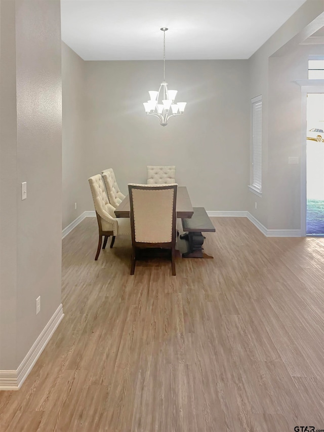 dining area featuring an inviting chandelier and light hardwood / wood-style floors