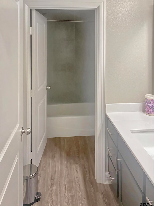 bathroom with vanity, hardwood / wood-style flooring, and a tub