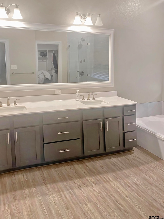 bathroom featuring vanity, shower with separate bathtub, hardwood / wood-style floors, and crown molding