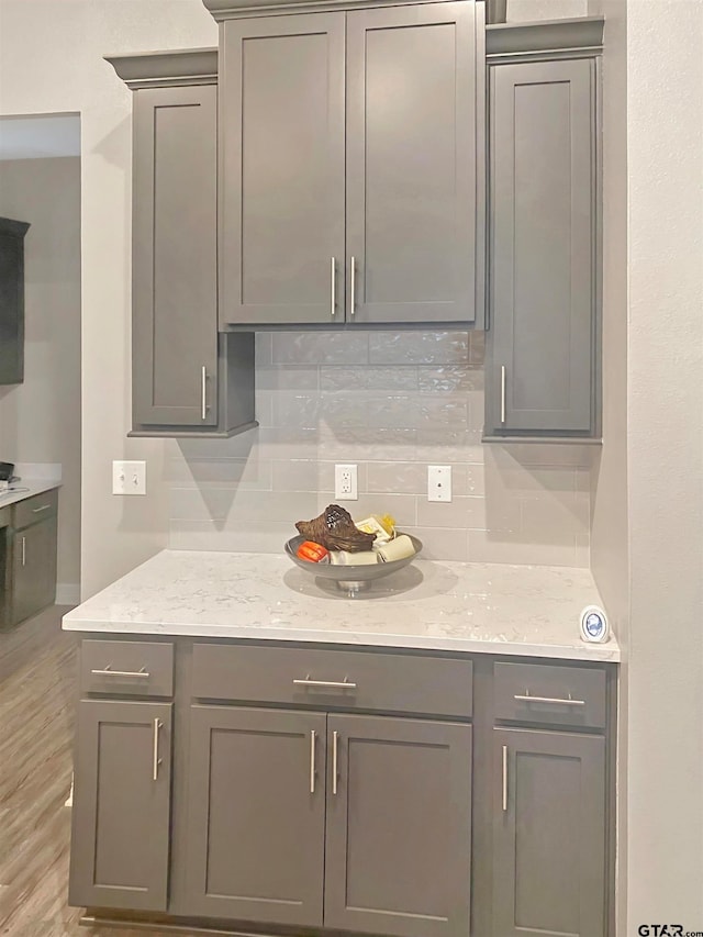 kitchen featuring gray cabinetry, decorative backsplash, and light hardwood / wood-style flooring