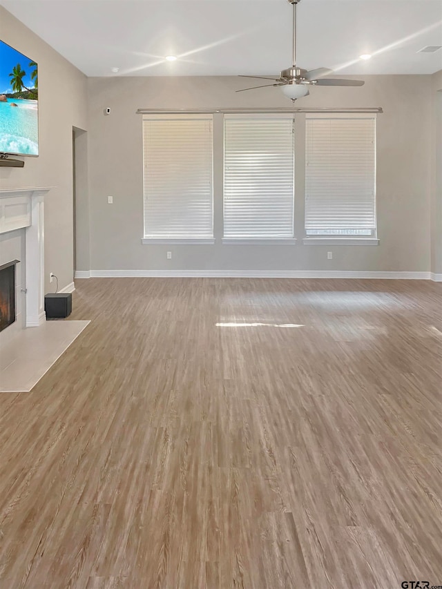 unfurnished living room featuring ceiling fan and light hardwood / wood-style flooring