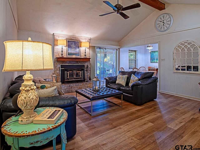 living room featuring hardwood / wood-style floors, a fireplace, vaulted ceiling with beams, and ceiling fan