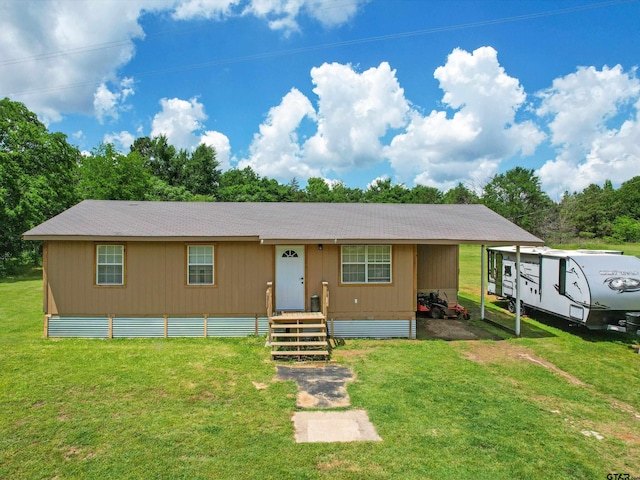manufactured / mobile home featuring a carport and a front yard