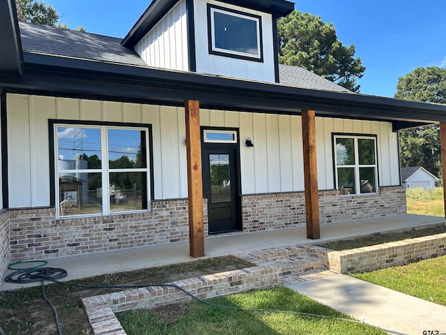 view of exterior entry featuring covered porch