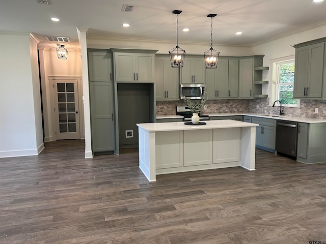 kitchen featuring stainless steel appliances, dark hardwood / wood-style floors, crown molding, a kitchen island, and decorative light fixtures