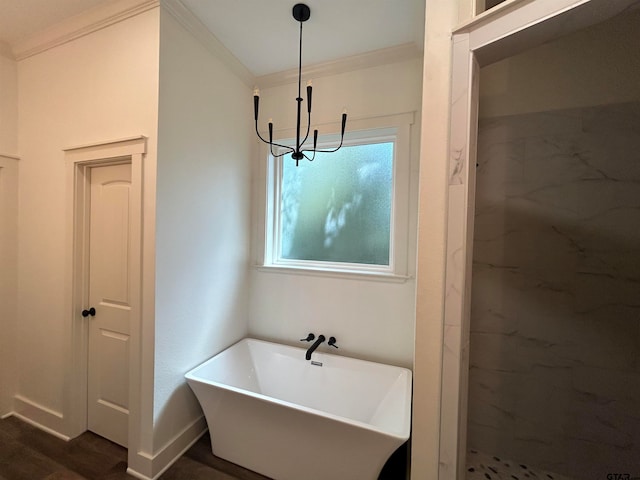 bathroom featuring hardwood / wood-style floors, a chandelier, a washtub, and ornamental molding