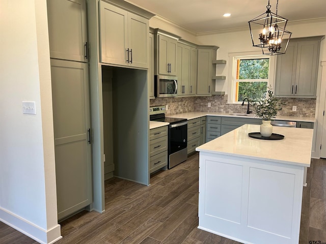 kitchen featuring dark hardwood / wood-style flooring, a center island, sink, ornamental molding, and appliances with stainless steel finishes