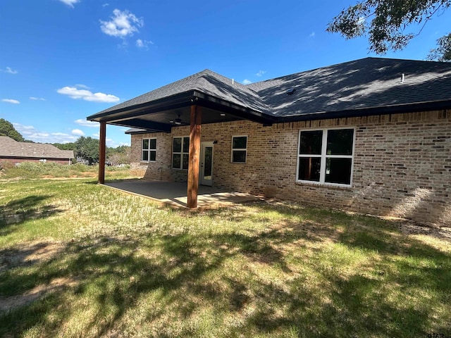 rear view of property featuring a yard and a patio