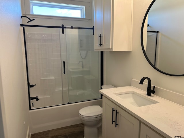 full bathroom with toilet, vanity, hardwood / wood-style flooring, and enclosed tub / shower combo