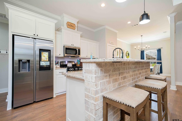 107 Hay Meadow Dr, Winona, TX 75792 - kitchen featuring appliances with stainless steel finishes, wood finished floors, crown molding, white cabinets, and light stone countertops