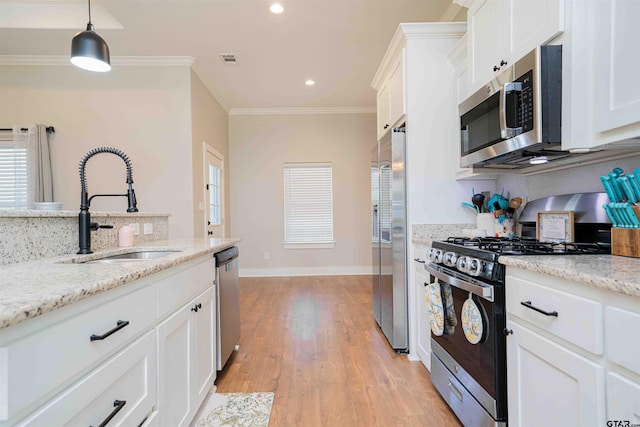 107 Hay Meadow Dr, Winona, TX 75792 - kitchen with appliances with stainless steel finishes, a sink, ornamental molding, white cabinets, and light wood-type flooring