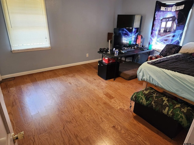 bedroom with wood finished floors and baseboards