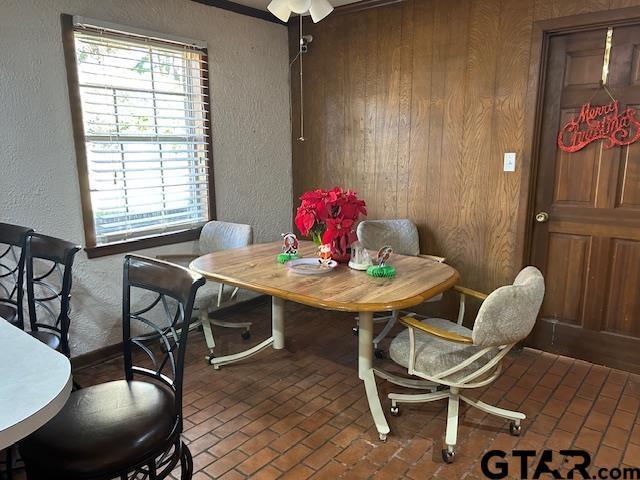 dining area with brick floor and a textured wall