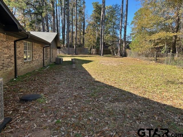 view of yard with central AC unit and a fenced backyard