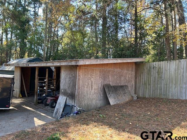 view of outdoor structure featuring an outbuilding and fence