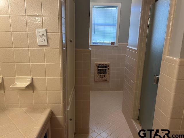 full bathroom with a stall shower and tile walls