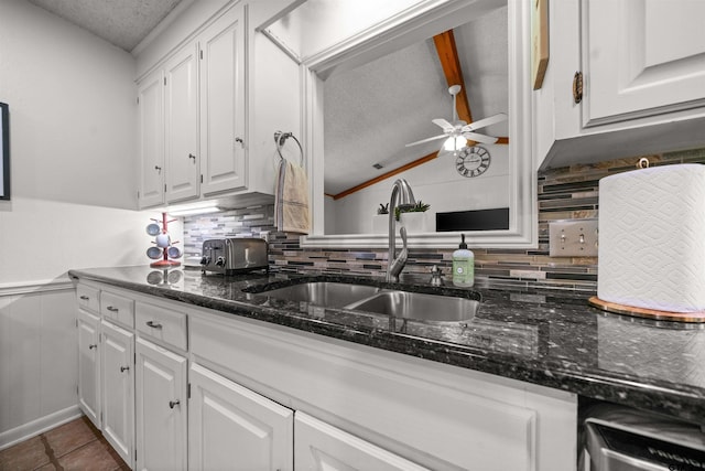 1430 Wavely St, Tyler, TX 75701 - kitchen with a textured ceiling, a sink, tasteful backsplash, white cabinetry, and lofted ceiling