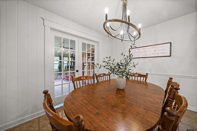 1430 Wavely St, Tyler, TX 75701 - tiled dining area with french doors, a chandelier, a textured ceiling, and a decorative wall