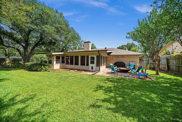 1430 Wavely St, Tyler, TX 75701 - back of house with a sunroom, a chimney, a patio area, a fire pit, and brick siding