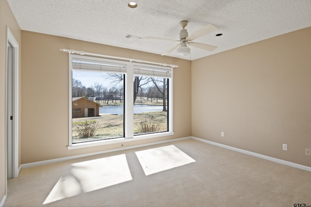 unfurnished room featuring visible vents, light colored carpet, baseboards, and a textured ceiling