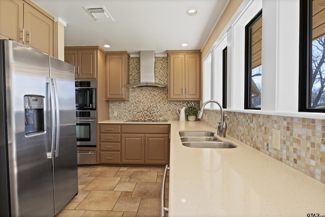 kitchen with visible vents, plenty of natural light, a sink, stainless steel appliances, and wall chimney exhaust hood