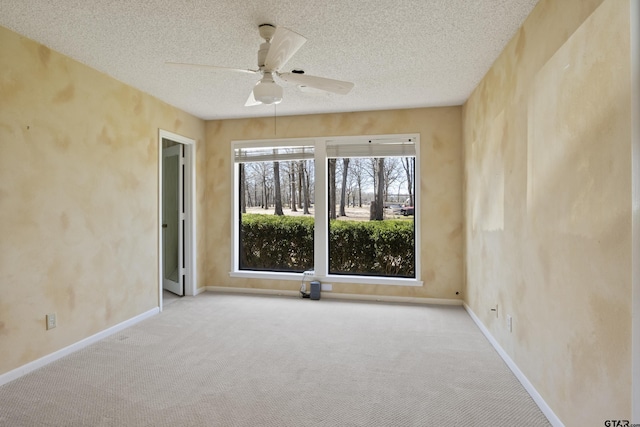 unfurnished room featuring a textured ceiling, carpet, baseboards, and ceiling fan