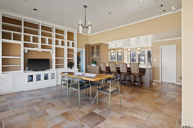 dining space with visible vents, crown molding, stone finish flooring, and an inviting chandelier
