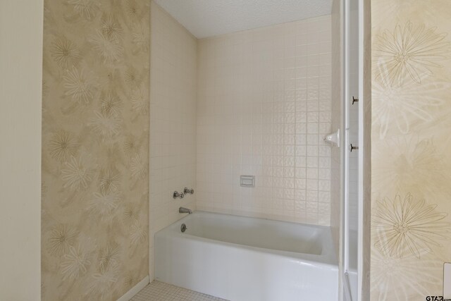 full bathroom featuring wallpapered walls, baseboards, tile patterned flooring, and a textured ceiling