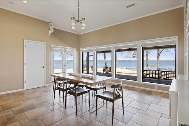 dining room featuring visible vents, baseboards, a water view, ornamental molding, and a notable chandelier