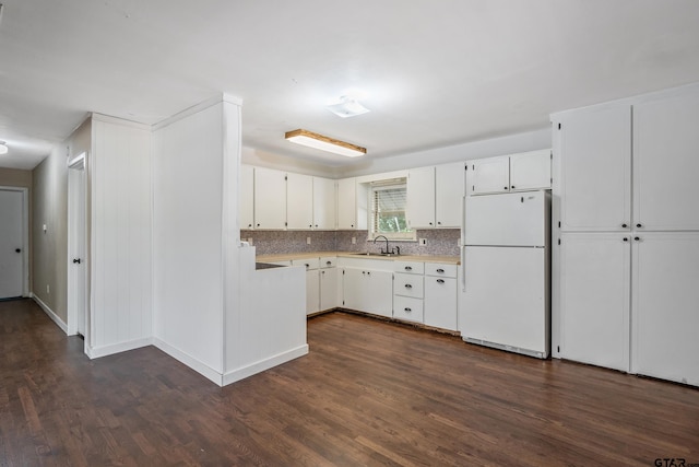 kitchen featuring sink, tasteful backsplash, white cabinets, white fridge, and dark wood-type flooring