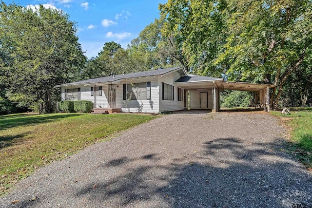 single story home with a front yard and a carport