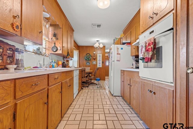 kitchen featuring light countertops, white appliances, and brown cabinetry