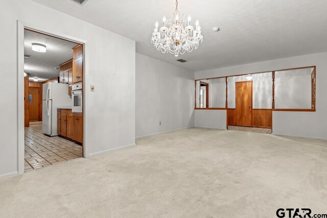 901 Dogwood St, Gilmer, TX 75644 - spare room with a chandelier, light carpet, and baseboards