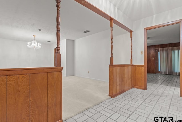 901 Dogwood St, Gilmer, TX 75644 - empty room featuring wood walls, a chandelier, and brick patterned floors