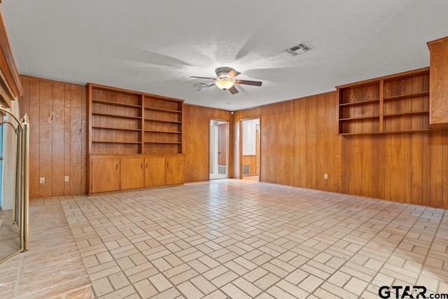 901 Dogwood St, Gilmer, TX 75644 - unfurnished living room with a ceiling fan, wooden walls, and brick patterned flooring