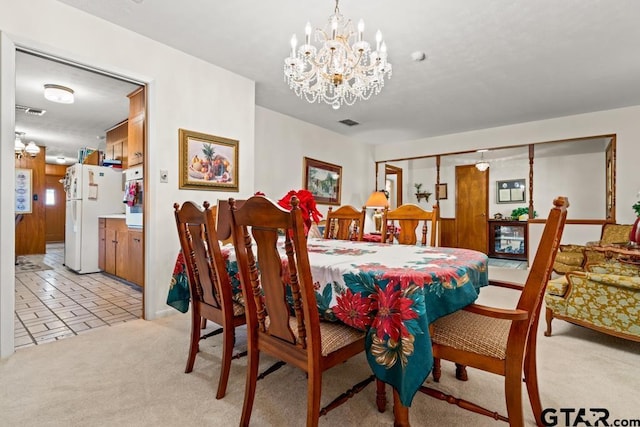 dining room featuring light colored carpet, visible vents, and an inviting chandelier