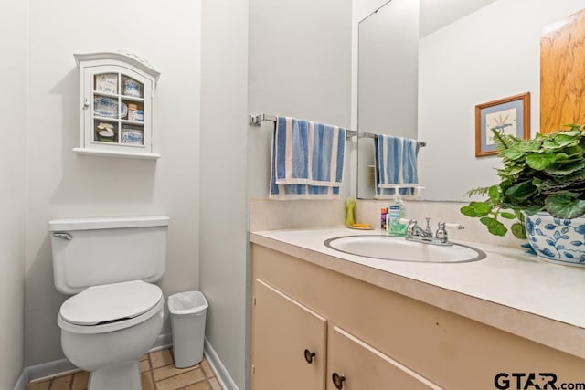 bathroom featuring vanity, toilet, and baseboards