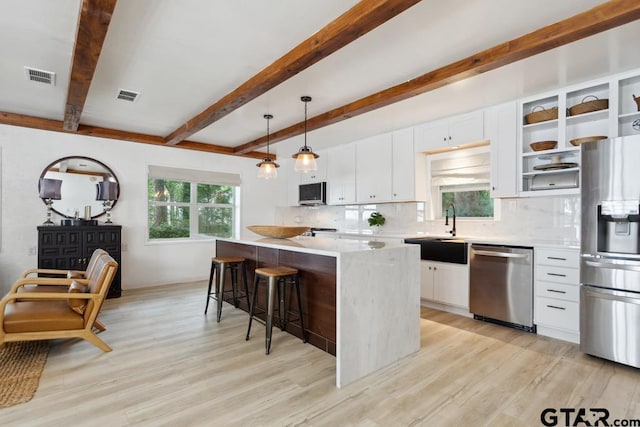 11020 Kevin Dr, Frankston, TX 75763 - kitchen featuring stainless steel appliances, open shelves, light wood-type flooring, backsplash, and a kitchen island